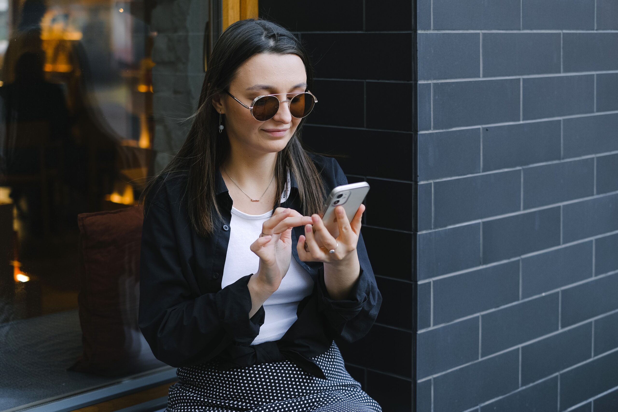 Trendy woman using a smartphone outdoors, representing app-based independent work