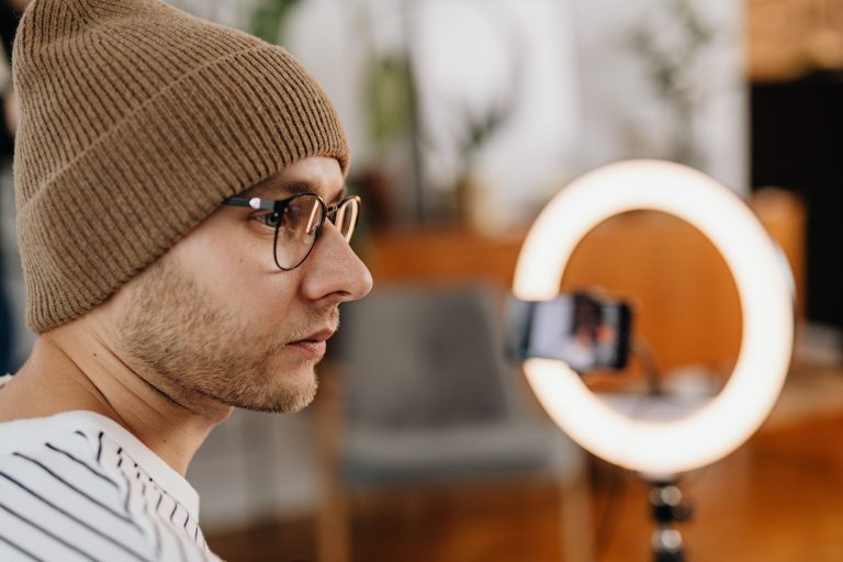 Everyday creator recording a video at home with a smartphone and ring light