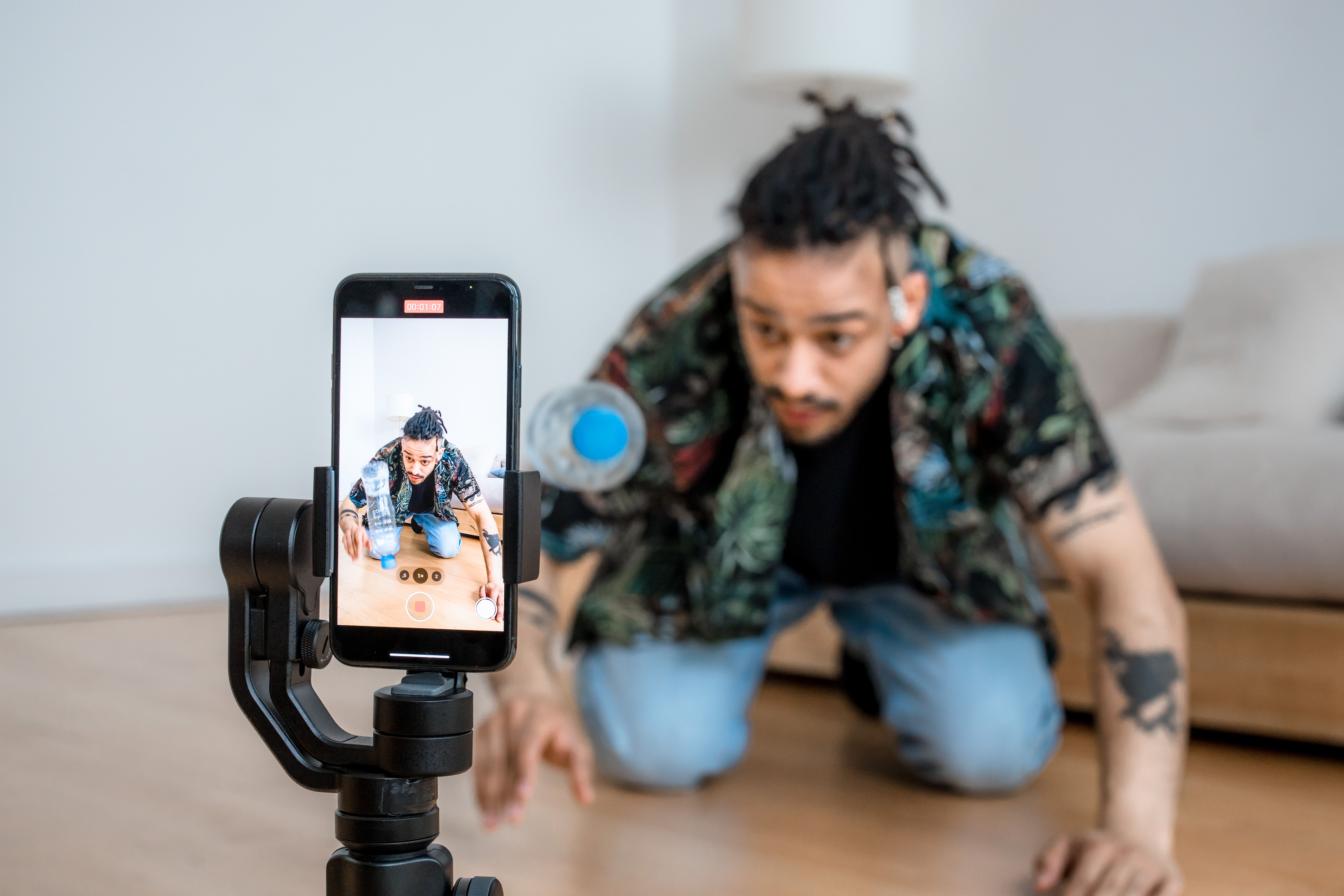 Man filming creative content with a smartphone on a gimbal indoors